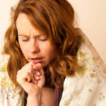 Sick woman cough in bed under blanket