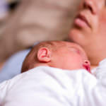 sleeping newborn baby, exhausted mother.