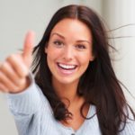 Portrait of attractive young woman showing a thumbs up