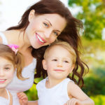 Image of cute young female with two little children read book ou