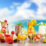 Summer cocktails with pieces of fruit on wooden table