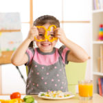 child girl eating vegan food having fun in kindergarten