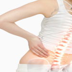 Digital composite of Highlighted spine of woman with back pain