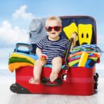 Baby In Travel Suitcase. Kid Inside Luggage Packed For Vacation