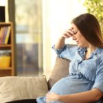 Worried pregnant woman at home