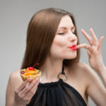 Portrait of young woman enjoying the cake