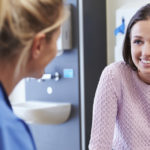 Female Patient And Nurse Have Consultation In Hospital Room