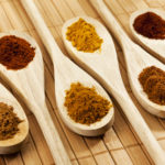 Six spices on wooden spoons