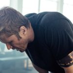Portrait of a young fitness man exhausted after intense workout at crossfit gym
