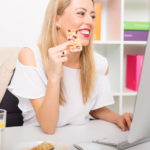 54246992 – woman having granola bar while working