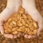 Almond in hands shaping heart