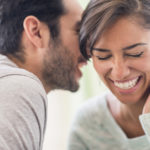 Couple whispering together indoors