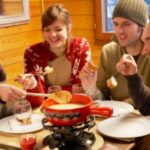 group of young people eating fondue in a chalet