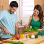 Attractive man and woman prepping low calorie dinner in kitchen