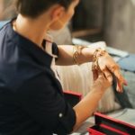 Closeup on young woman trying jewelry. rear view