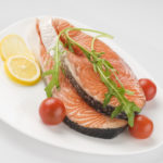 Raw salmon steak with herbs and tomatoes
