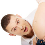 Father talking to mother’s pregnant tummy