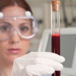 Female lab technician analyzing a blood sample in a test tube