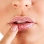Woman touching her lips with herpes