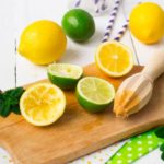 Lemons, limes, mint cocktail preparation on a wooden background