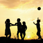 Silhouette, group of happy children playing on meadow, sunset, s