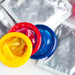 Couple of Colorful condoms with packaging, isolated on white