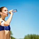 woman athlete takes a break,  she drinking water, out on a run o