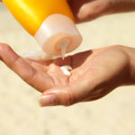 women squeezing suncream
