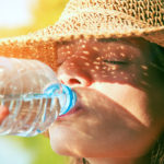 Woman drinking water in summer sunlight
