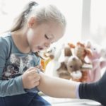 little-girl-looking-at-injured-knee-in-classroom-640966137-5c38f3e2c9e77c000101499a