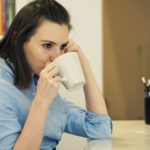 young-businesswoman-relaxing-and-drinking-coffee-sitting-by-table-at-home_ekcrqgfu__F0000
