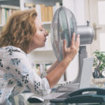 Woman suffers from heat in the office or at home