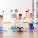 Children doing exercise with weights .