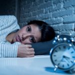 woman in bed late night trying to sleep suffering insomnia