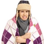 Young man covered with a blanket feeling cold