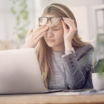 Young tired working woman at work