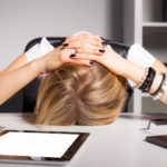 Tired business woman resting her head on desk