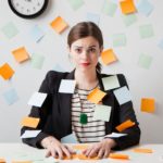 Studio shot of young woman working in office covered with adhesive notes. Image shot 2012. Exact date unknown.