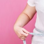 1047-woman measures her waist with measuring tape