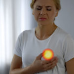 Woman feels pain in breast, checking mammary gland, tightness symptoms of cancer