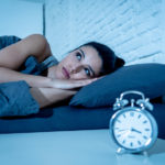 pretty latin woman can’t sleep in insomnia concept