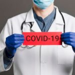 doctor-holding-covid-19-card_23-2148445988