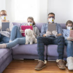 Family at home sofa with mask and tablet pc in quarantine isolation
