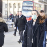 Young woman wearing face mask while walking in the streets of London