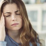 Young woman with headache in home interior