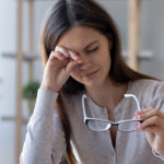 Tired woman rubbing eyes feeling fatigue from glasses computer work