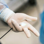 Endoscopic examination conducted in the hospital. Selective focus on doctor`s hands. Closeup.