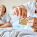 condom-sex-safety-sexual-couple-bed-together-happy-smile-use-protection-happiness-love-man-woman-open-birth-control-contraceptive-package-protect-against-std-sti-hiv
