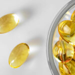 Fish oil capsules (omega-3) in a glass bowl. Close-up, white background. Flat lay, nutritional supplements.