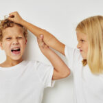 Photo of two children in white T-shirts are standing next to childhood unaltered